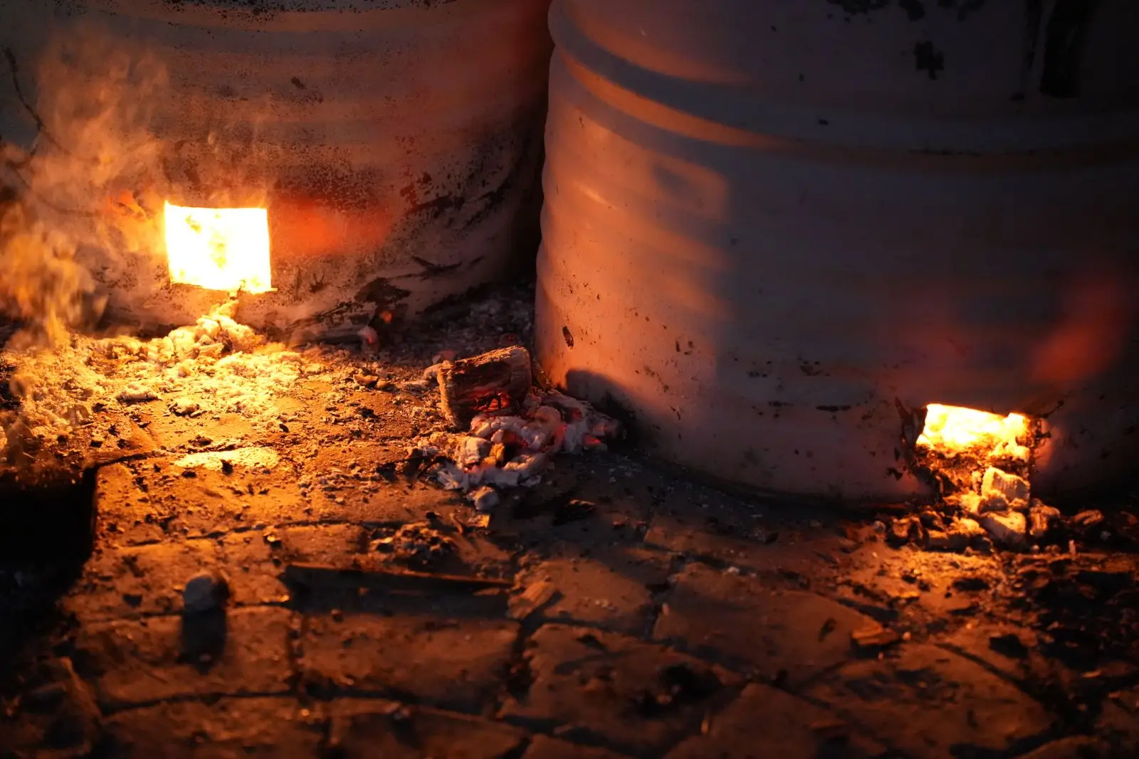 A brick kiln glowing with fire and embers at night